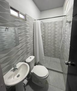 y baño con aseo, lavabo y ducha. en HOTEL HAUSE San Antero Córdoba, en San Antero
