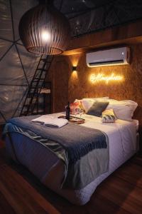 a bedroom with a large bed with a ladder on the wall at Glamping Atmosphera in Cambará