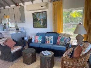 a living room with a blue couch and two chairs at Sunnyside home in Savannah Sound