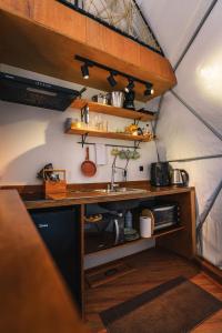 uma cozinha com um lavatório e um balcão num quarto em Glamping Atmosphera em Cambará