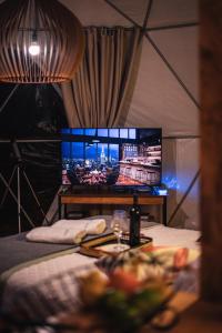 a room with a bed and a tv in a tent at Glamping Atmosphera in Cambara do Sul