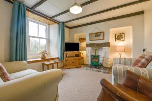 a living room with a couch and a tv at The Farmhouse in Penzance