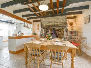 a kitchen and dining room with a wooden table and chairs at The Farmhouse in Penzance