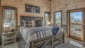a bedroom with a bed and a desk and windows at Clocking Inn in Mineral Bluff