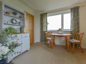eine Küche mit Tisch und Stühlen und einem Fenster in der Unterkunft The Quillet in Penzance