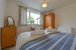 a bedroom with a blue and white bed with a window at The Quillet in Penzance