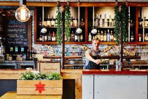 a man behind the counter of a bar at A Spacious 2BR Apt with an Amazing View Over Darling Harbour in Sydney