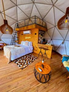 um quarto numa tenda com uma cama e uma mesa em Glamping Atmosphera em Cambará