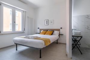 um quarto branco com uma cama e uma janela em Shiny Rooms Verona em Verona