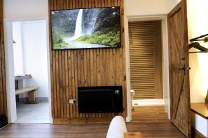 een woonkamer met een tv aan een muur met een waterval bij Slaymaker Cottage in Oakworth