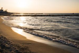 una playa con un muelle y el océano en Mielno Apartament, en Unieście