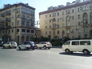 um grupo de carros estacionados em frente aos edifícios em Квартира в Баку в тихом дворе em Baku