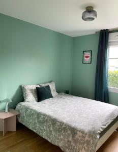een slaapkamer met een bed met blauwe muren en een raam bij Be My Guest - Proche Disneyland Paris in Quincy-Voisins