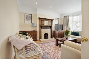 un soggiorno con divano e camino di 5 bed with parking and large private garden a Finchley
