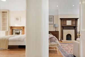 een slaapkamer met een bed en een open haard bij 5 bed with parking and large private garden in Finchley