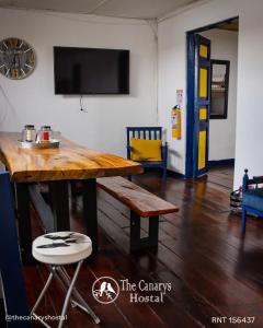 una mesa de madera y un banco en una habitación en The Canarys Hostal, en Santa Rosa de Cabal