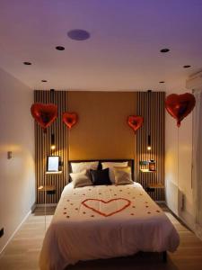a bedroom with a bed with hearts on it at Studio moderne St Germain les Corbeil - jacuzzi privatif in Saint-Germain-lès-Corbeil