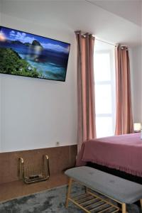a bedroom with a bed and a tv on the wall at Carla Apartment Opuzen Modern Oasis and Comfort in Opuzen