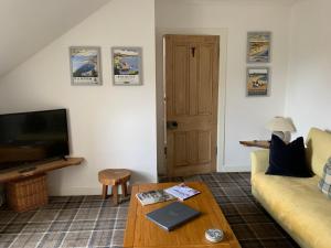 a living room with a couch and a coffee table at Cameron Cottage in Inverkip