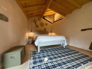 a bedroom with a bed and a blue and white rug at Casa do Bernardino in Cabril