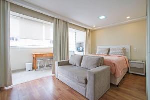 a bedroom with a bed and a couch and a table at Studio Business Alto da Boa Vista - Perto do Consulado e Transamérica in Sao Paulo +34 photos