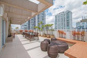 a rooftop patio with a table and chairs and buildings at Studio Business Alto da Boa Vista - Perto do Consulado e Transamérica in Sao Paulo