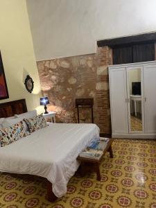 a bedroom with a large bed and a table at Boutique Colonial House Hotel in Santo Domingo
