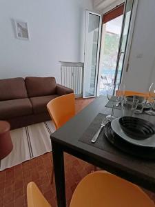 ein Wohnzimmer mit einem Tisch, Stühlen und einem Sofa in der Unterkunft [Forti Genova-Free Parking] Castellaccio Apartment 2 in Genua