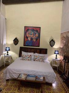 a bedroom with a bed and a painting on the wall at Boutique Colonial House Hotel in Santo Domingo