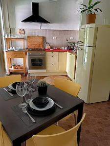 eine Küche mit einem Tisch mit Tellern und Weingläsern in der Unterkunft [Forti Genova-Free Parking] Castellaccio Apartment 2 in Genua