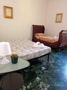 Zimmer mit 2 Betten und einem Tisch mit einer Lampe in der Unterkunft [Forti Genova-Free Parking] Castellaccio Apartment 2 in Genua