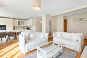 - un salon avec deux canapés blancs et une table dans l'établissement LE PAQUIER - Appartement de standing près du lac, à Annecy