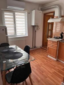 a kitchen with a glass table and some chairs at Medeea in Zalău