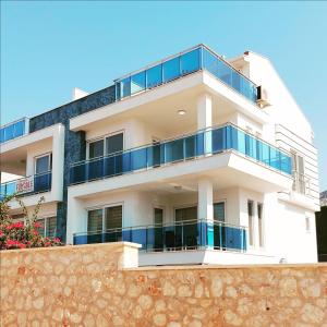 ein weißes Gebäude mit blauen Balkonen auf einer Wand in der Unterkunft Penthouse duplex "il GiraSole suite" in Kalkan