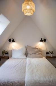 a bedroom with a white bed with two pillows at Idyllisches Landhaus, Garten & Kaminofen, perfekt für Paare in Häven