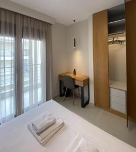 1 dormitorio con escritorio, 1 cama y 1 mesa en Toumba apartments, en Tesalónica