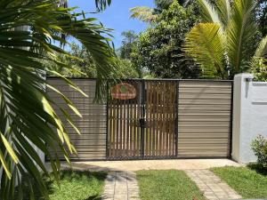 brama w ogrodzeniu z drewnianymi drzwiami w obiekcie Villa Green Space w mieście Matara