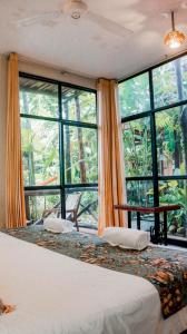 a bedroom with a bed and large windows at La Patarashca in Tarapoto