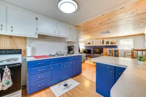 een keuken met blauwe kasten en een aanrecht bij Lakefront New London Home Dock, Fire Pit and Views! in New London