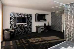 Zimmer mit einem Schreibtisch und einem TV an der Wand in der Unterkunft Titan Centrum Apartman in Nyíregyháza