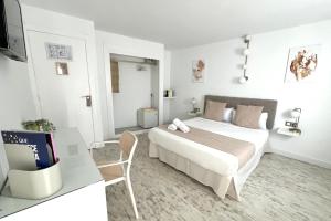 a bedroom with a bed and a desk with a tv at Aldara Sitges in Sitges