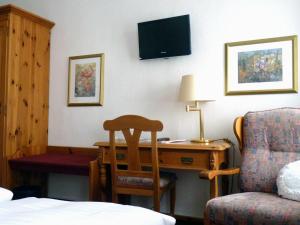 ein Hotelzimmer mit einem Schreibtisch und einem Stuhl in der Unterkunft Gasthof Willenbrink in Lippetal