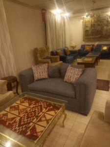 a living room with a couch and a table at سهول الكرمل للشقق الفندقية in Amman