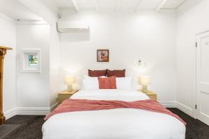1 dormitorio con 1 cama blanca grande y 2 lámparas en Beautiful Spacious 3BR, en Auckland