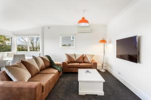een woonkamer met een bank en een tv bij Beautiful Spacious 3BR in Auckland