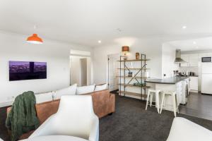 een woonkamer met een bank en een tafel bij Beautiful Spacious 3BR in Auckland