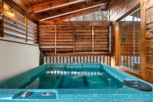 a large blue tub in a room with a window at Private! Hot Tub, Views, & Games in Sevierville