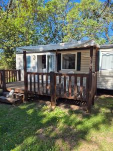 a mobile home with a porch and a deck at Paisible camping les 7 fonds in Agde