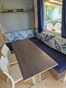 a table and a couch in a tiny house at Paisible camping les 7 fonds in Agde