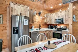 a kitchen with a stainless steel refrigerator and wooden cabinets at Private! Hot Tub, Views, & Games in Sevierville